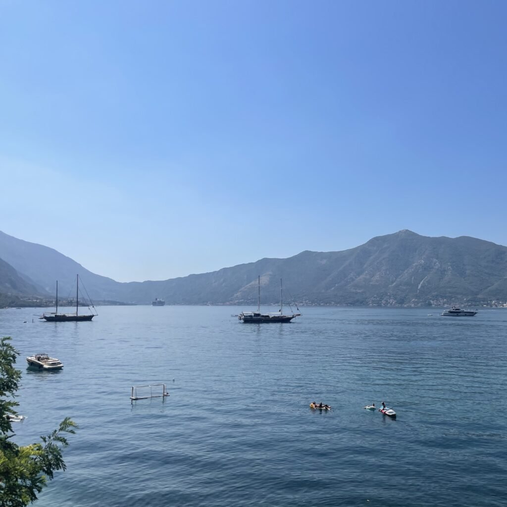 Vista panoramica della Baia di Kotor con mare calmo e montagne sullo sfondo
